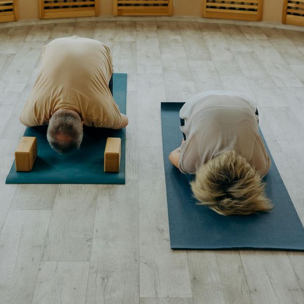 A diverse group of people of different ages practicing yoga together in a bright studio.
